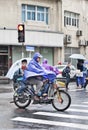Father and kids dressed in rainwear on an e-bike, Shanghai, China